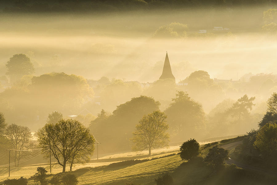 Golden mist at sunrise with the Parish church of St Peter, Hope village. English Peak District. UK. Photograph by John Finney Photography