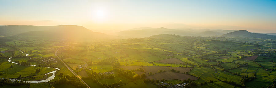 Golden sunset aerial panorama over idyllic green summer countryside mountains Photograph by fotoVoyager