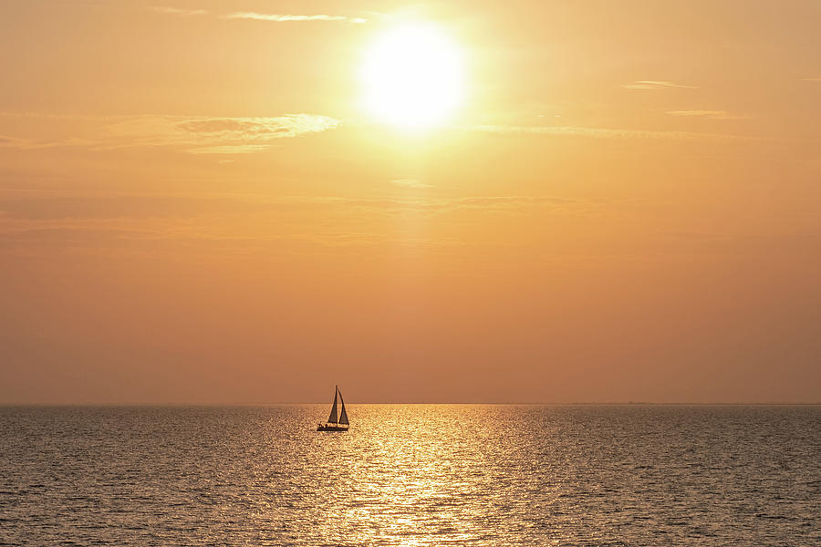 Golden Sunset Seascape with a Sailboat in the middle of the Sea under the Sun Photograph by Alexios Ntounas
