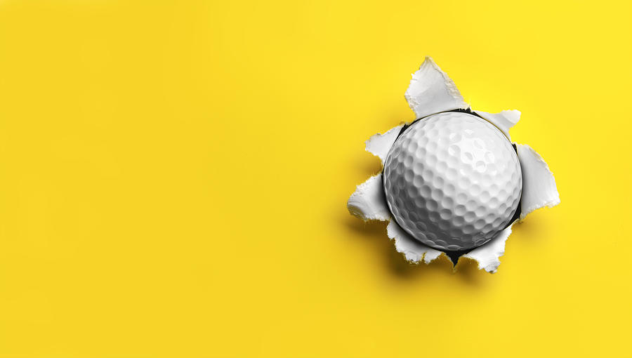 Golf Ball stuck in Yellow Paper Photograph by Burwellphotography