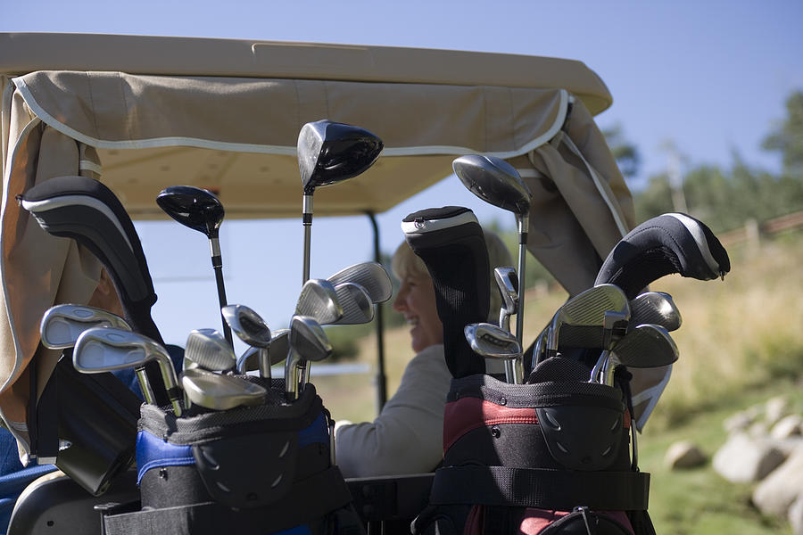 Golf clubs in golf cart Photograph by Comstock Images