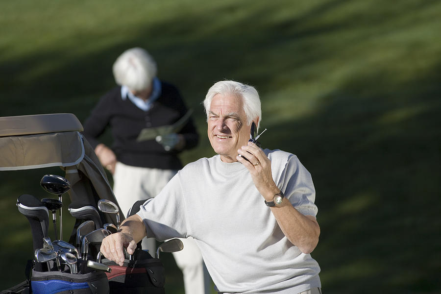 Golfer on cell phone Photograph by Comstock Images