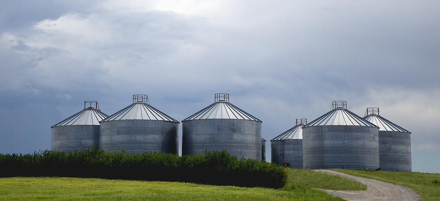 Grain bins with stormy sky beyond Photograph by Timothy Hearsum
