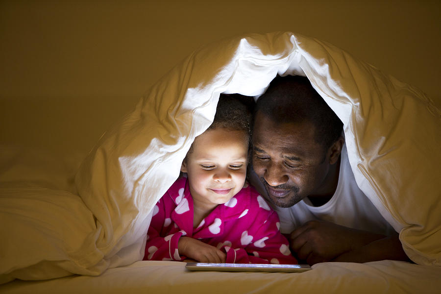 Grandfather And Granddaughter In Bed Photograph by SolStock