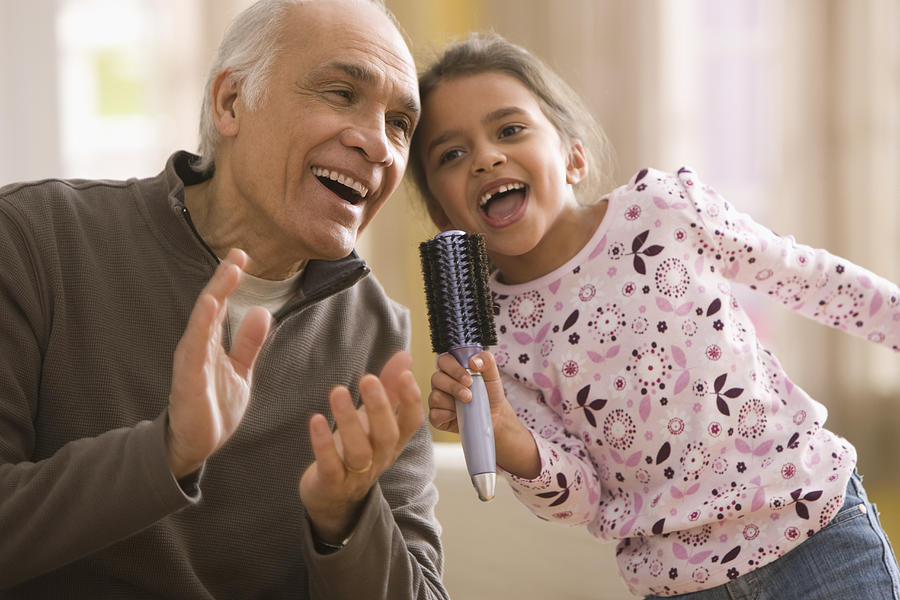 Grandfather and granddaughter singing together Photograph by Jose Luis Pelaez Inc