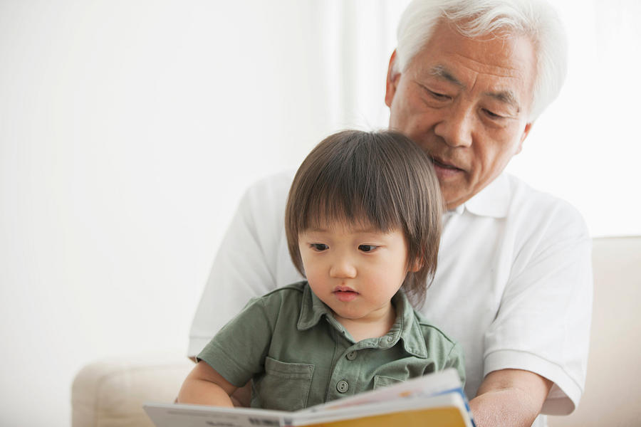Grandfather reading to grandson Photograph by Takahiro Igarashi