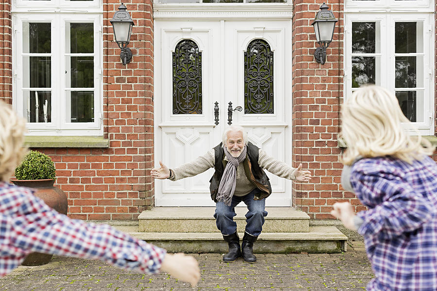 Grandfather welcoming grandchildren with arms open Photograph by Nils Hendrik Mueller