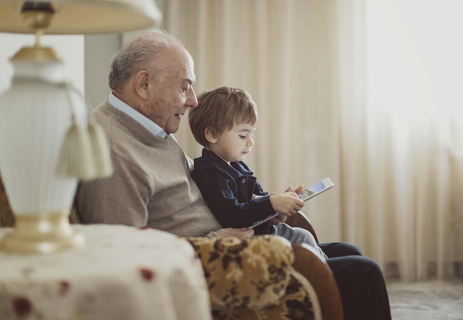Grandfather with his grandson looking a digital tablet Photograph by Thanasis Zovoilis