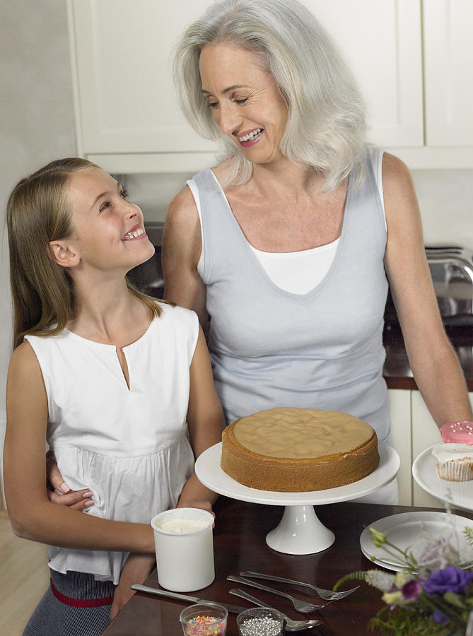 Grandmother and Granddaughter Looking Face to Face in a Kitchen Photograph by Digital Vision.