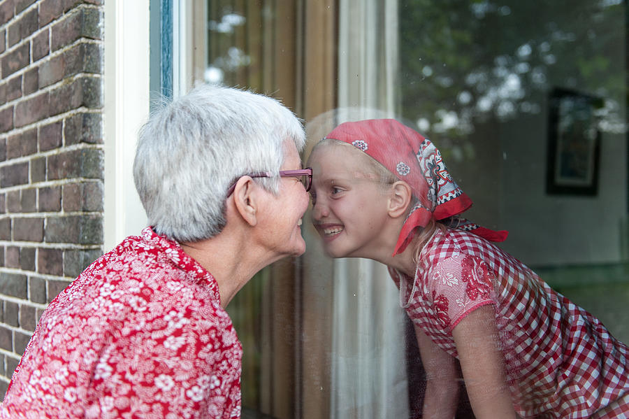 Grandmother and granddaughter nosing lovingly Photograph by Lucy Lambriex