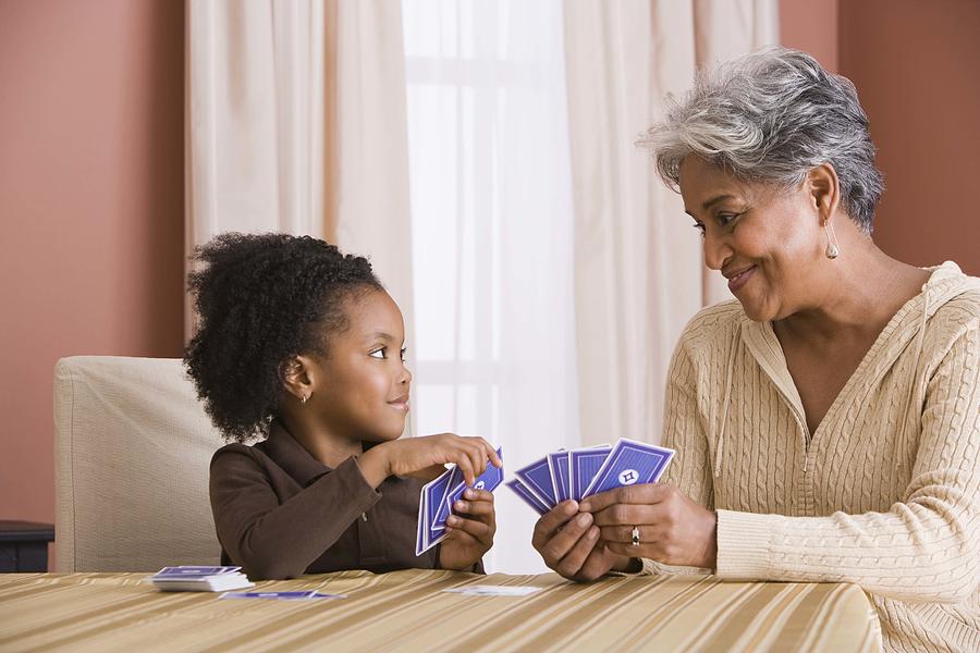 Grandmother and granddaughter playing cards Photograph by Jupiterimages