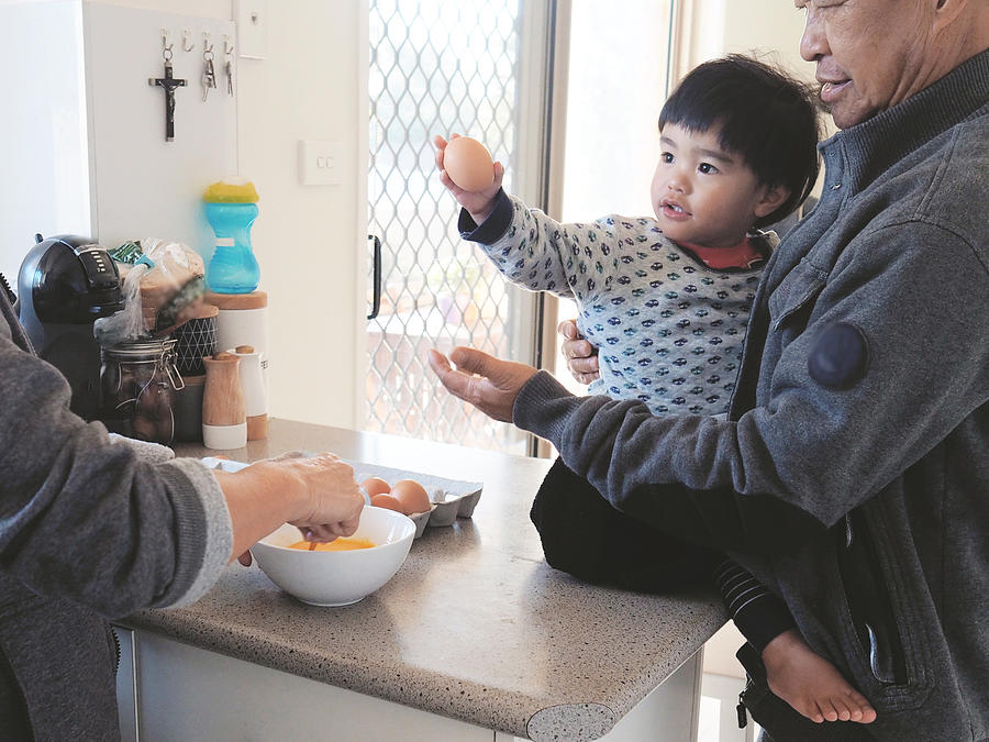Grandparents Are Whisking An Egg And Preparing Breakfast With Toddler Photograph by Lesley Magno
