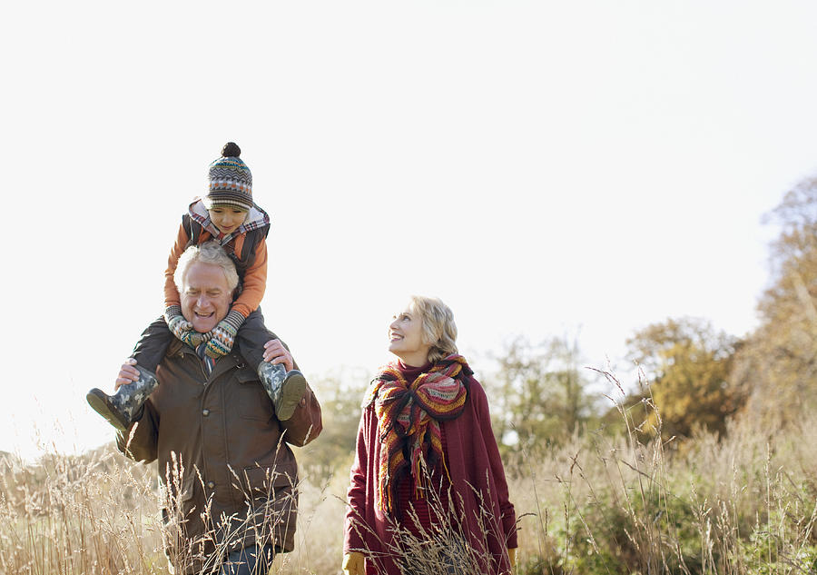 Grandparents walking outdoors with grandson Photograph by Paul Bradbury
