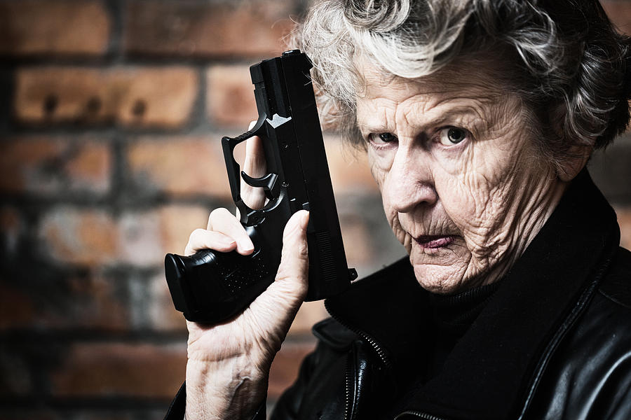 Granny get your gun! Fierce old woman holds pistol Photograph by RapidEye