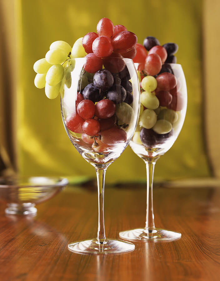 Grapes in wine glasses Photograph by Armstrong Studios