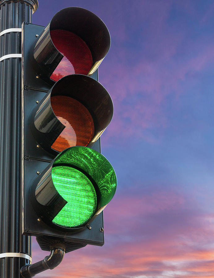 Green light on traffic signal against sunrise as concept for permission Photograph by Steven Heap