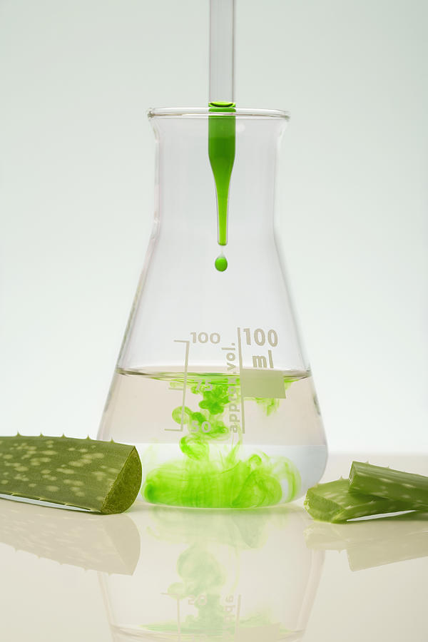 Green liquid in pipette and beaker, bits of plant Photograph by Geir Pettersen