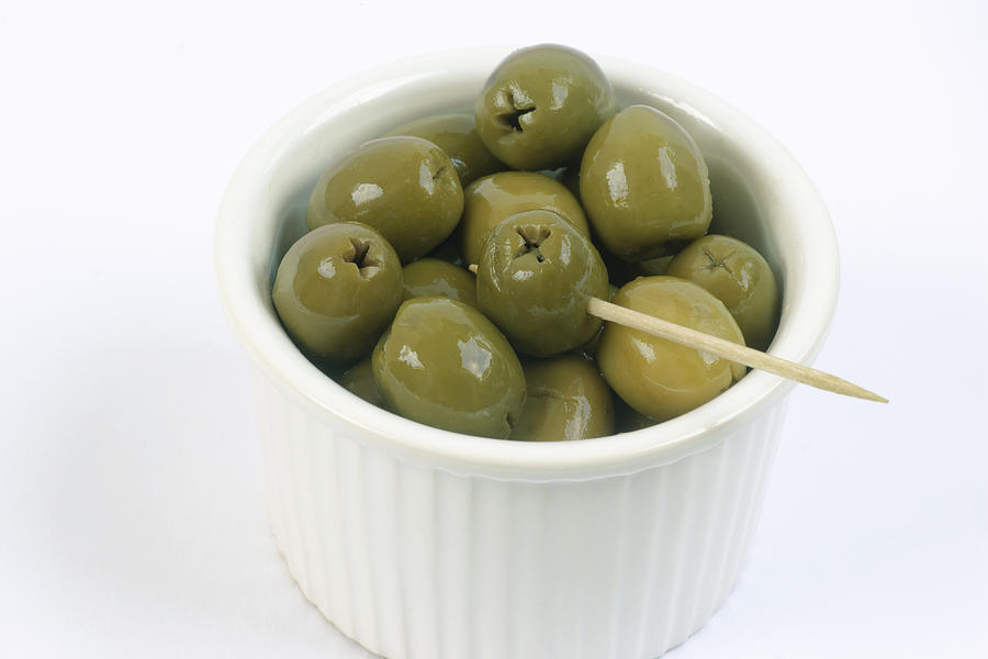 Green olives in dish, close-up Photograph by Rosemary Calvert
