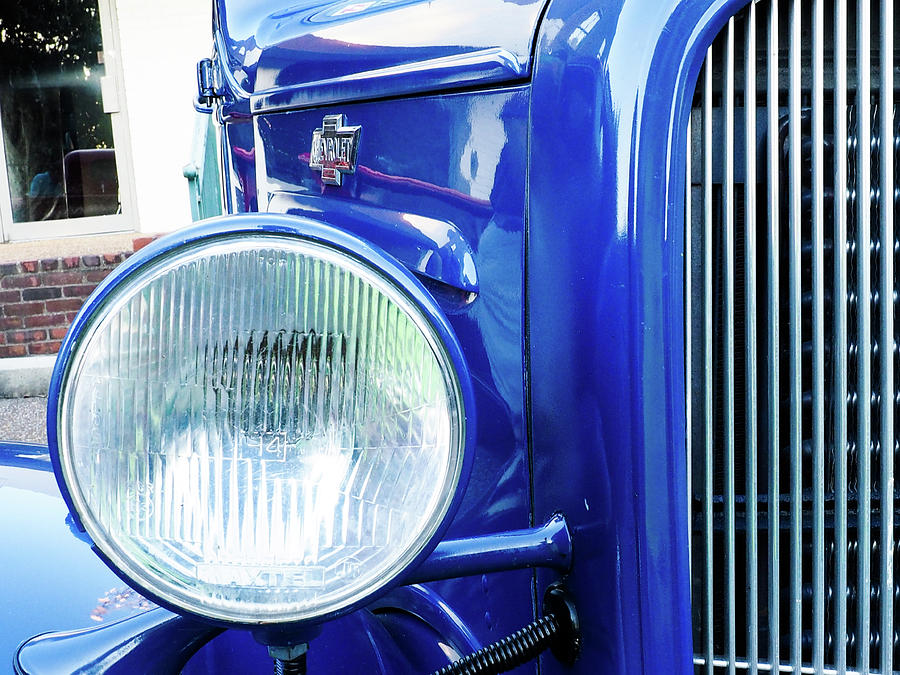 Grill And Headlight With A Blue Car Attached Photograph
