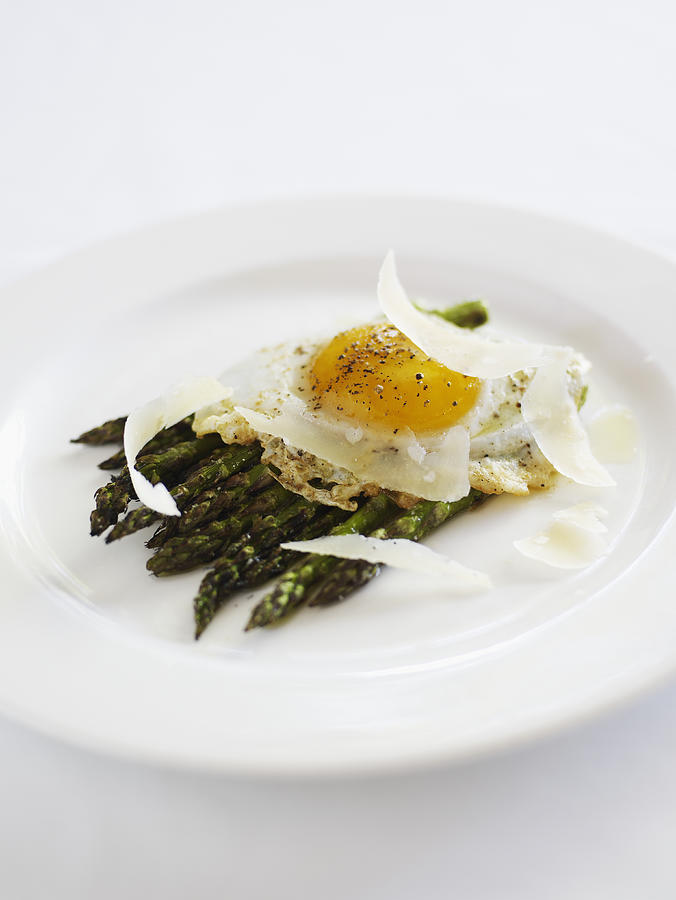 Grilled asparagus with parmesan and fried duck egg, close-up Photograph by Thomas Barwick