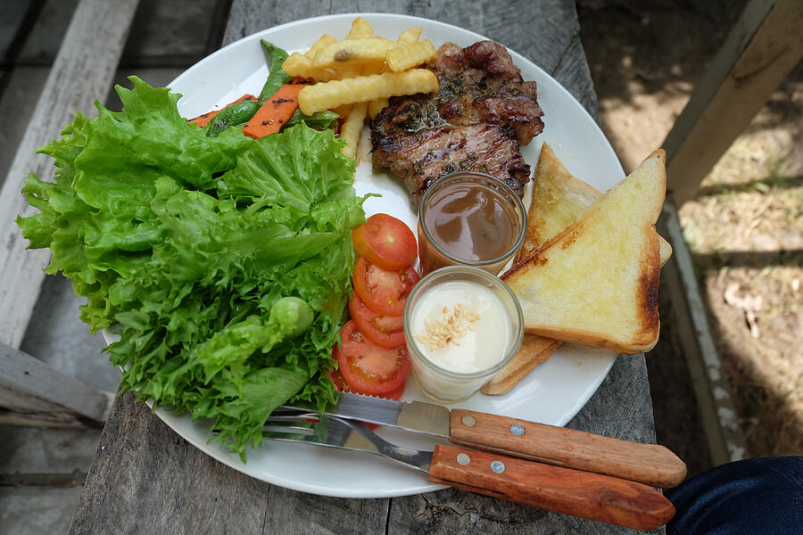Grilled steak, French fries, bread and vegetables Photograph by Spring26