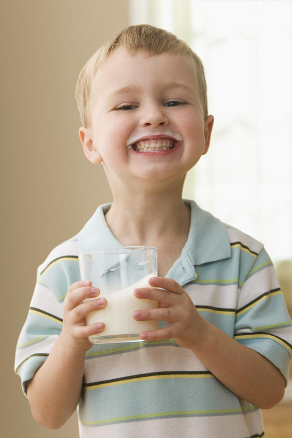 Grinning Caucasian boy drinking milk Photograph by Jose Luis Pelaez Inc
