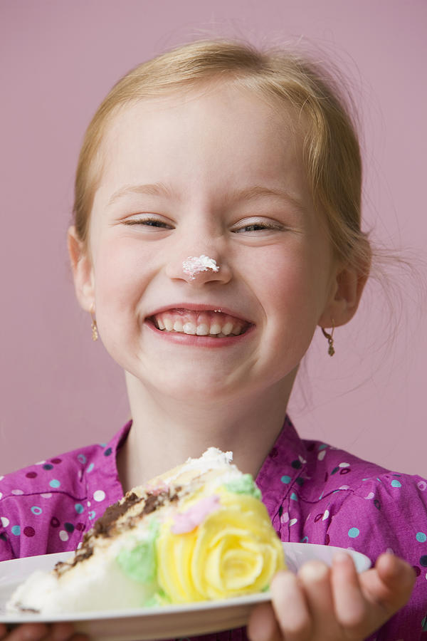 Grinning girl with birthday cake icing on her nose Photograph by Jose Luis Pelaez Inc