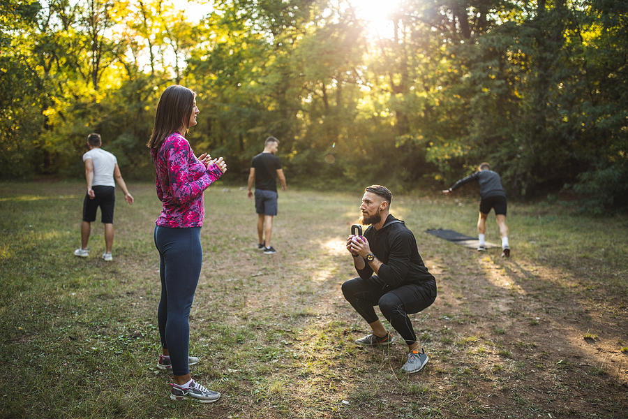 Group of athletes exercising outdoors Photograph by Freemixer