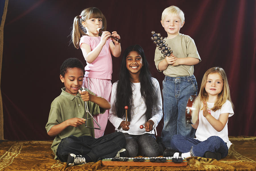 Group of children (4-9) performing on stage with musical instruments, portrait Photograph by Richard Lewisohn