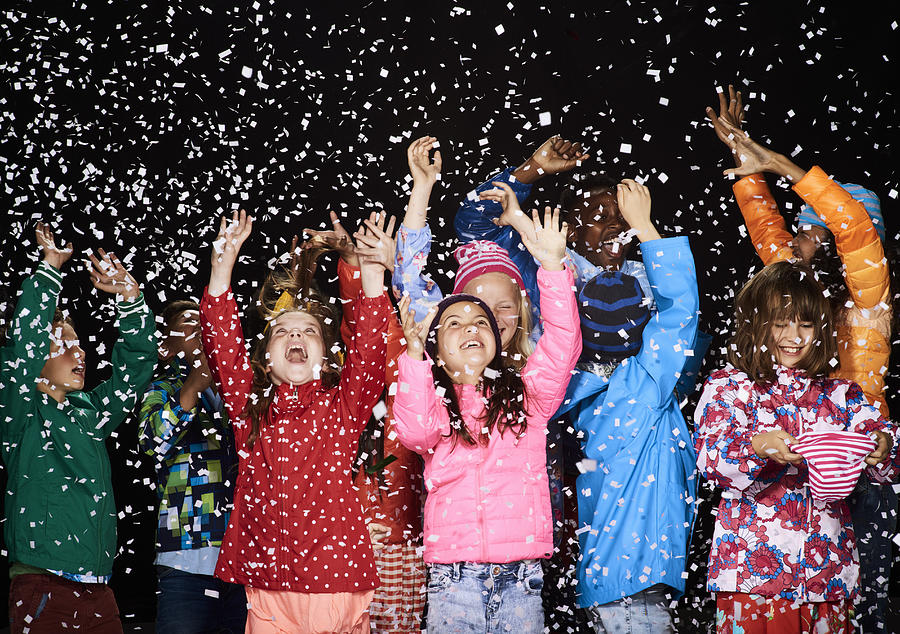 Group of children dressed in winter coats having fun in the snow Photograph by Flashpop