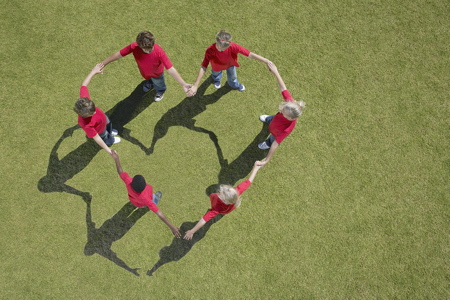 Group of children holding hands in heart-shape formation Photograph by Martin Barraud