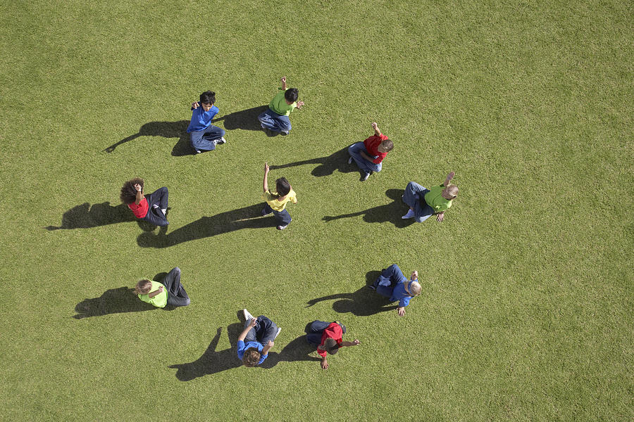 Group of children sitting in a circle playing Photograph by Martin Barraud