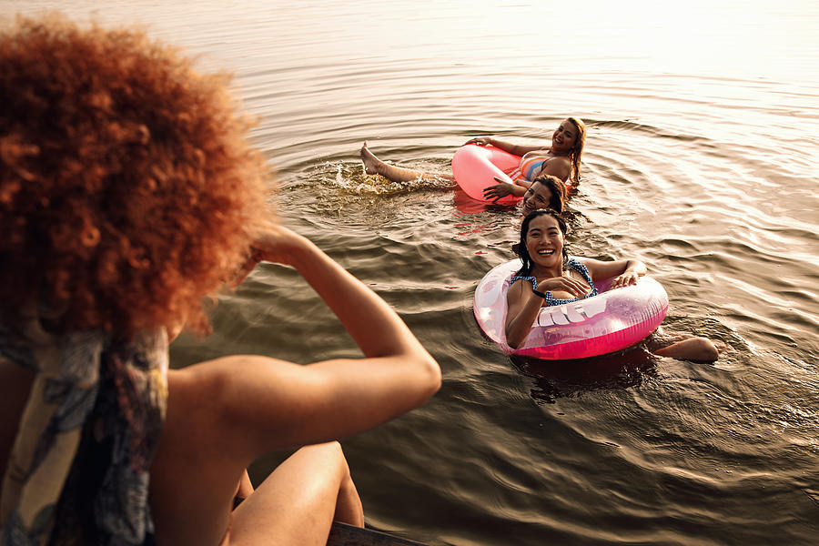 Group of female friends enjoying a summer day swimming at the lake. Photograph by Zoran Zeremski