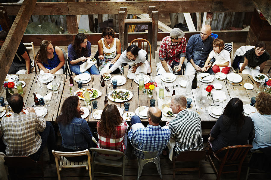 Group of friends and family dining overhead view Photograph by Thomas Barwick