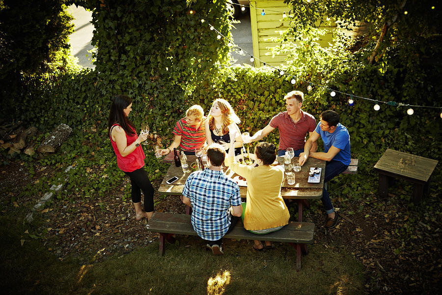 Group of friends at table sharing wine Photograph by Thomas Barwick