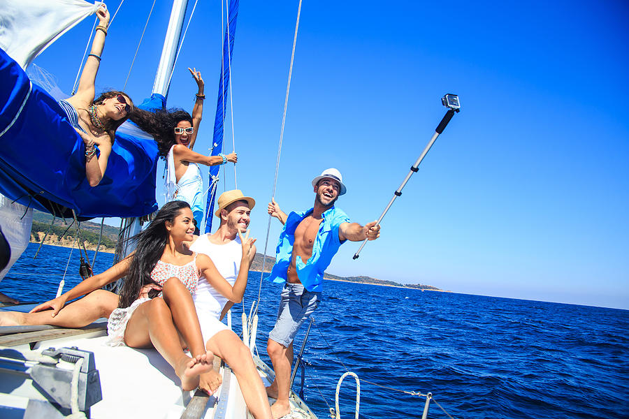 Group of friends having fun and making selfie on yacht Photograph by Valentinrussanov