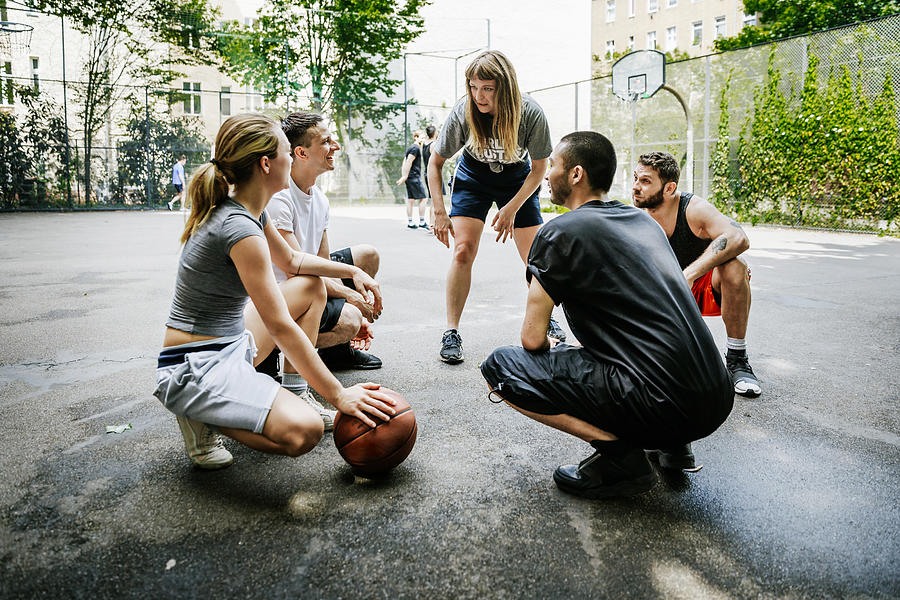 Group Of Friends Huddled Together Talking About Basketball Tactics. Photograph by Hinterhaus Productions