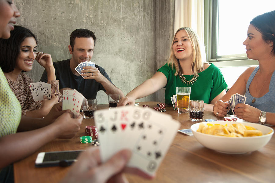 Group of friends playing cards around table Photograph by Corina Marie Howell