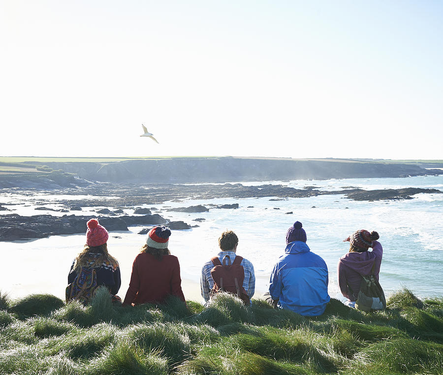 Group of friends sit on Atlantic coast. Photograph by Dougal Waters
