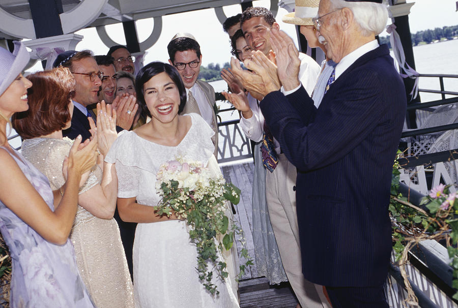 Group of guests applauding bride and groom at wedding ceremony Photograph by Buccina Studios