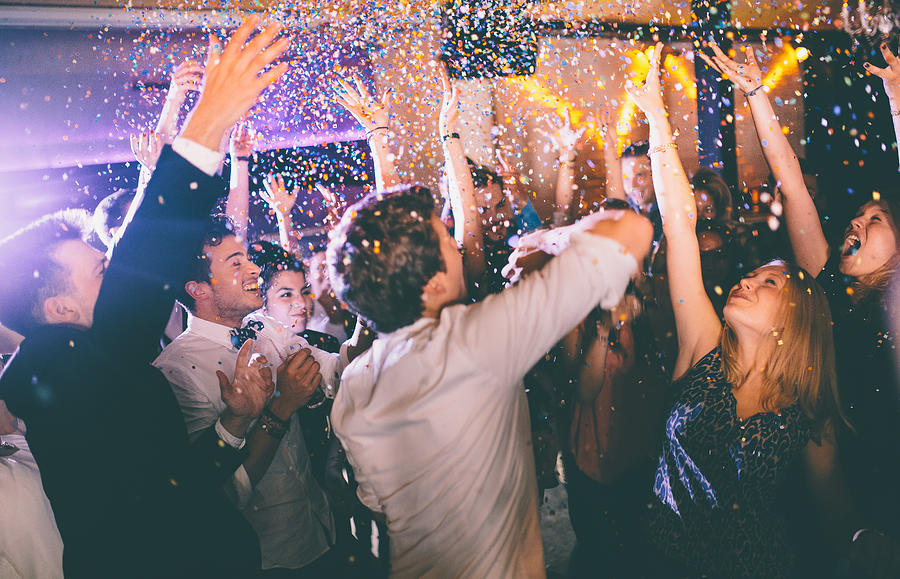Group of hipsters throwing confetti at a party in celebrations Photograph by Wundervisuals