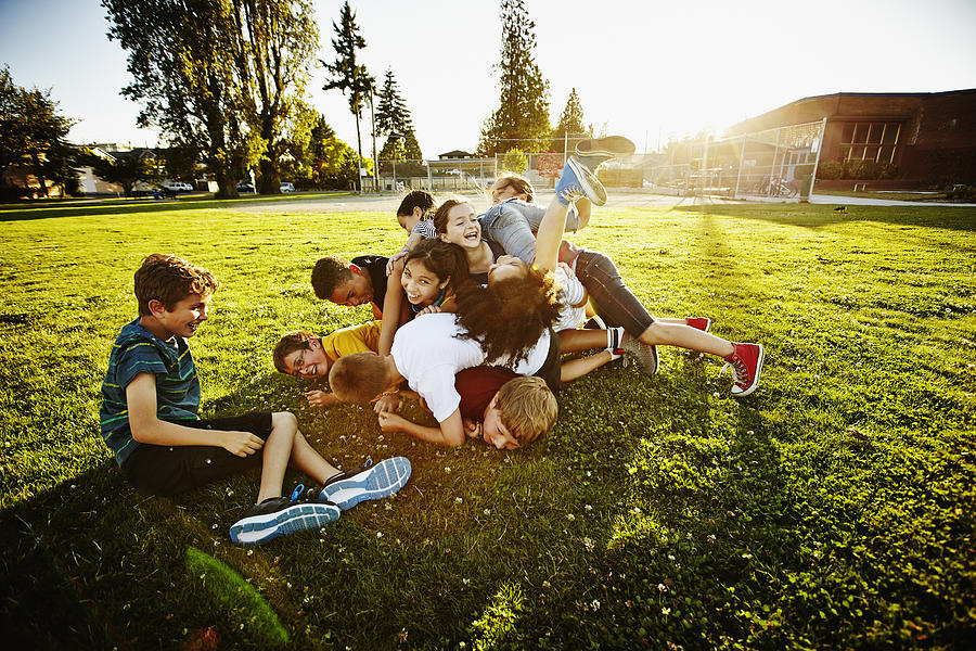 Group of kids tackling and piling on each other Photograph by Thomas Barwick