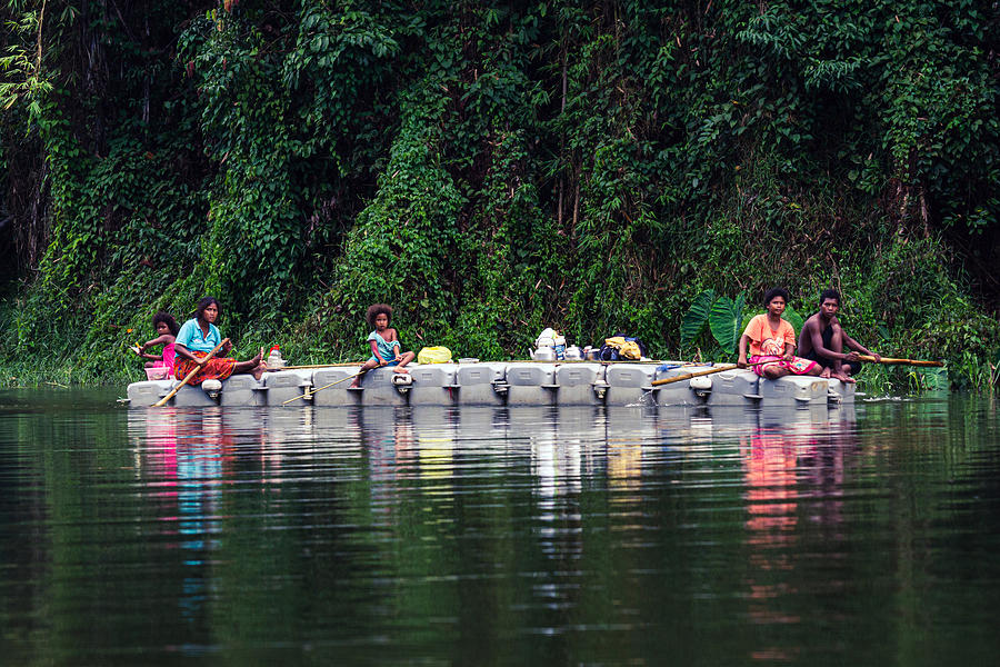 Group of local people paddling a boat going home as part of daily life on Royal Belum Rainforest Park. Photograph by Shaifulzamri