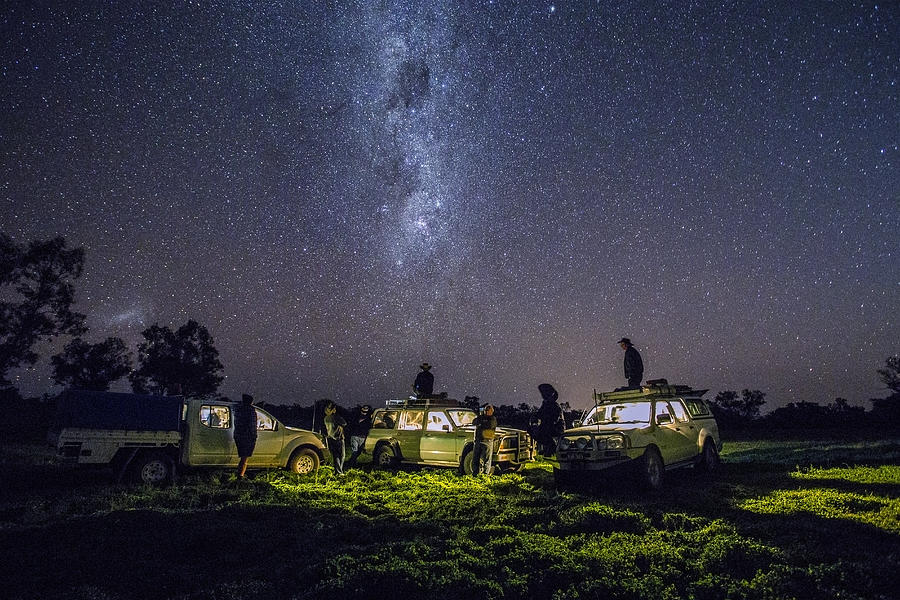 Group of men with four wheel drives look at stars Photograph by David Trood