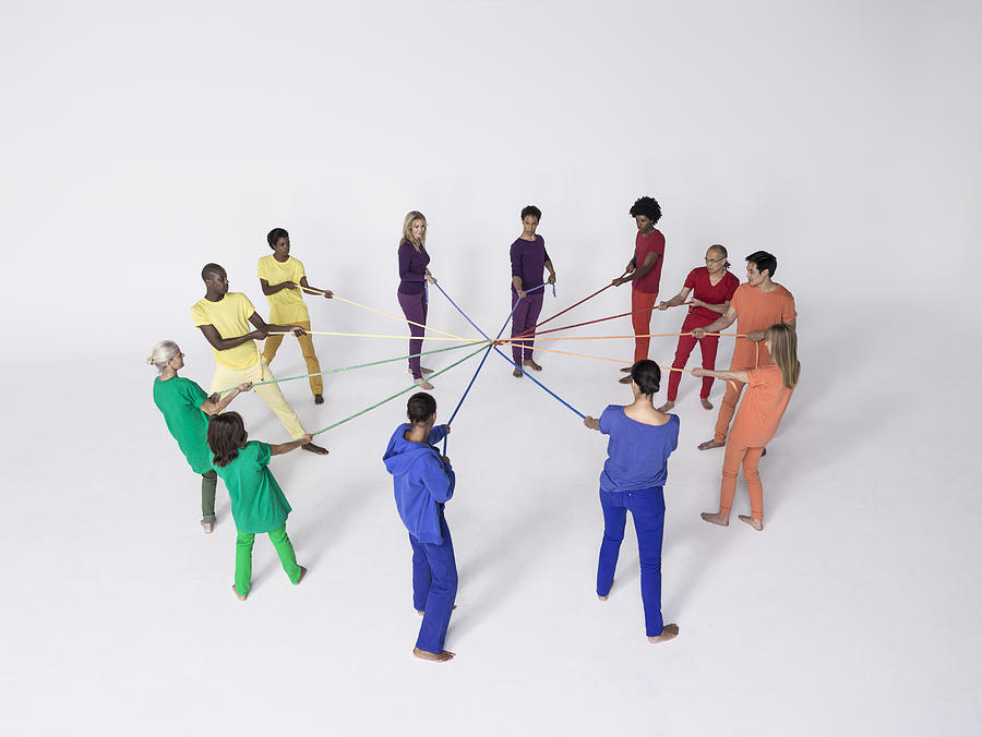 Group of people pulling connected color ropes Photograph by Nisian Hughes