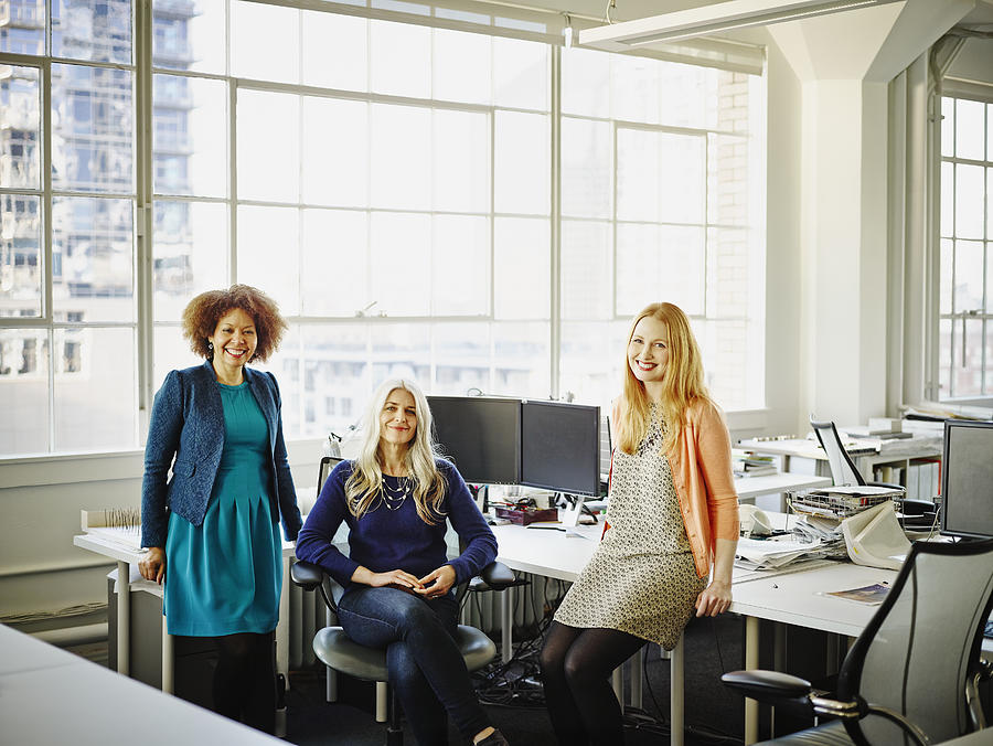 Group of smiling businesswomen in office Photograph by Thomas Barwick