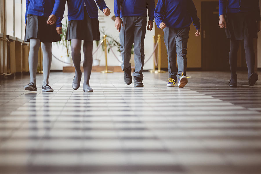 Group of students walking through school hallway Photograph by Izusek