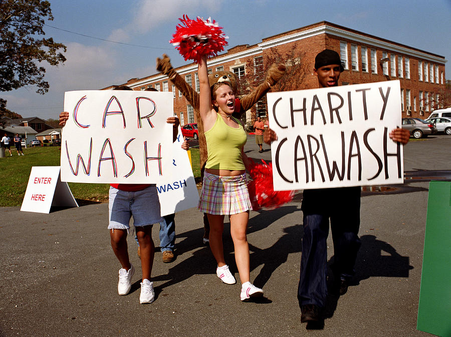 Group of teenagers (14-18) holding car wash signs girl cheering Photograph by Yellow Dog Productions