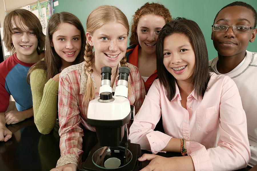 Group of teenagers at school with microscope Photograph by Comstock Images