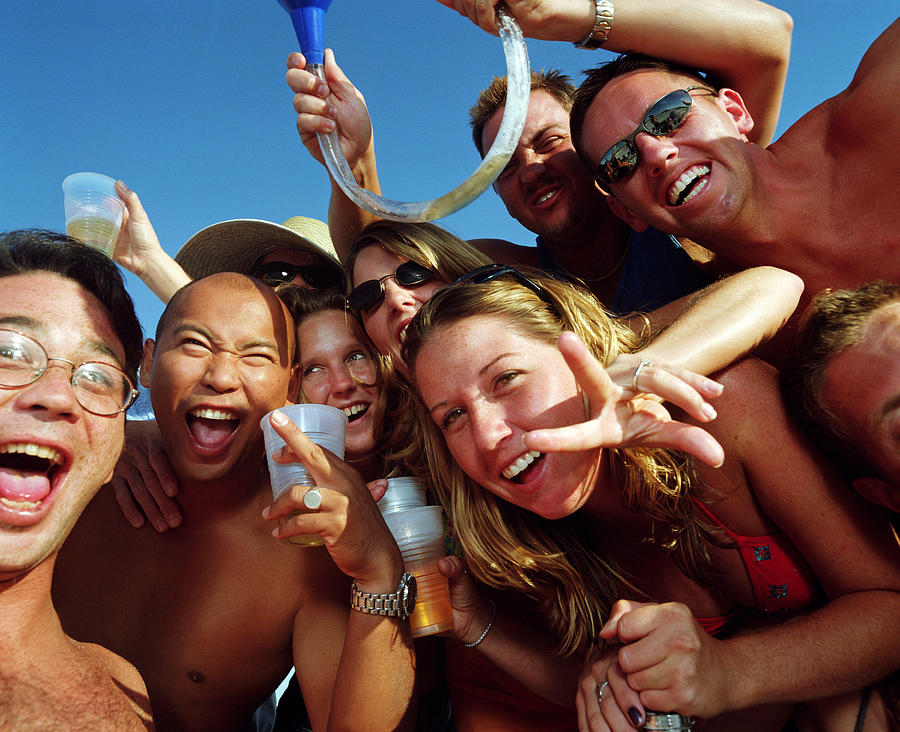 Group of young people wearing swimsuits, drinking beer, portrait Photograph by Sean Murphy